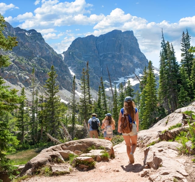 Family hiking on summer vacation in Colorado mountains.