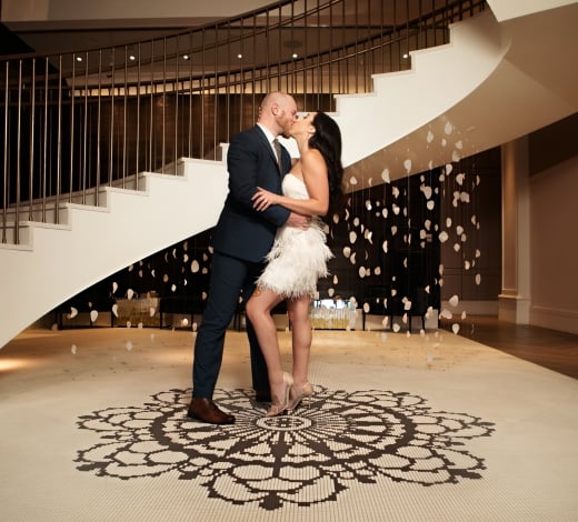 A couple kissing at the bottom of the stairs at The Elizabeth Colorado