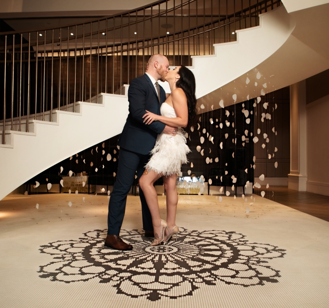 couple kissing at the bottom of the stairs