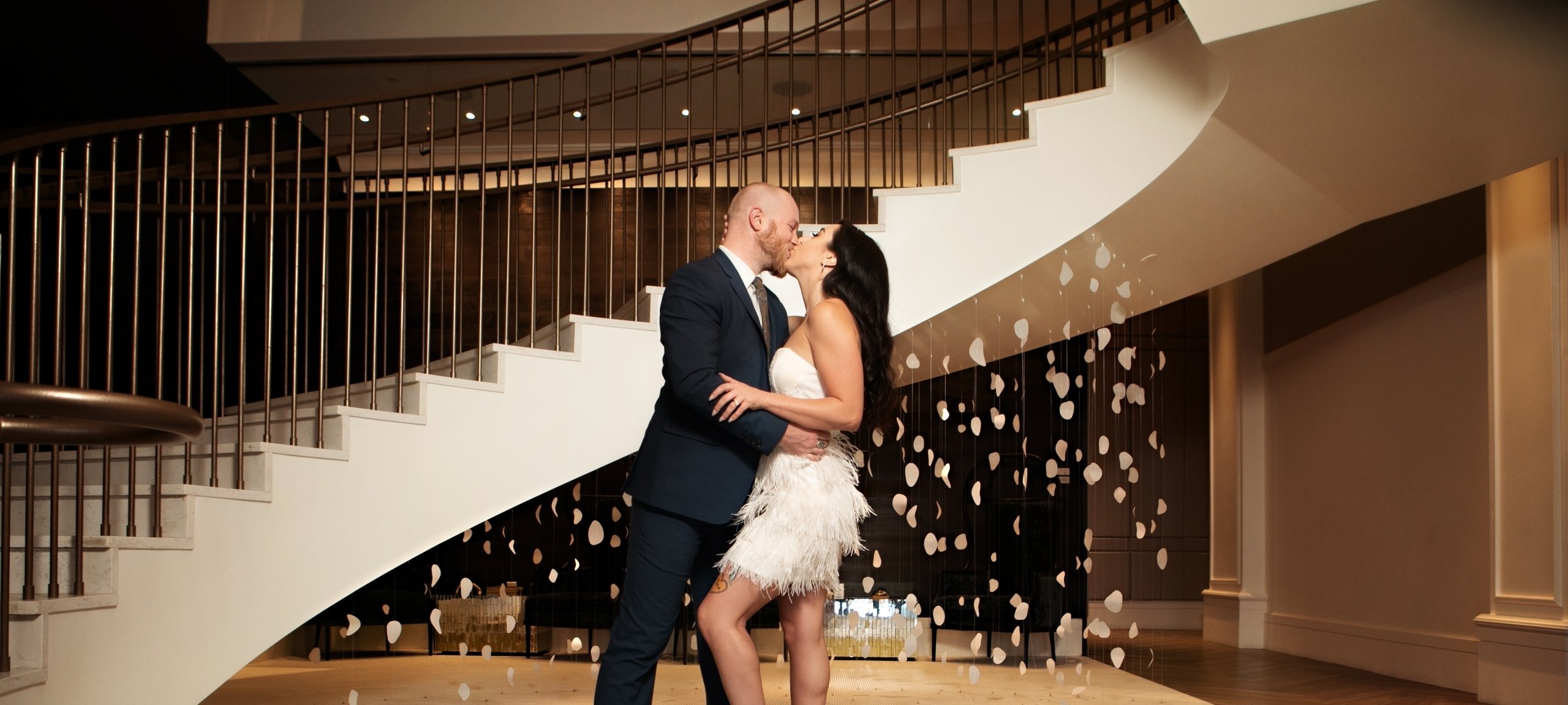 couple kissing at the bottom of the stairs
