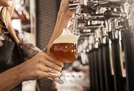 Hand of a Female bartender on a beer tap in bar