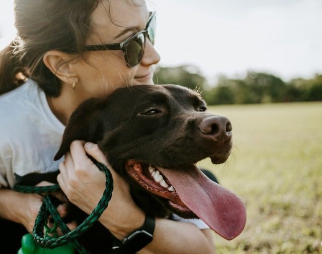 woman snuggling a dog