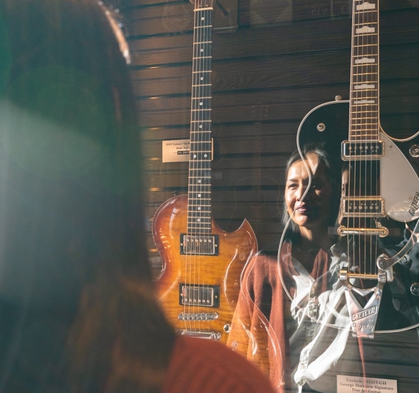 woman is looking at the guitar's collection