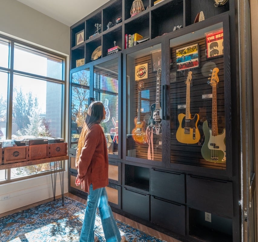 woman is looking at the guitar's collection