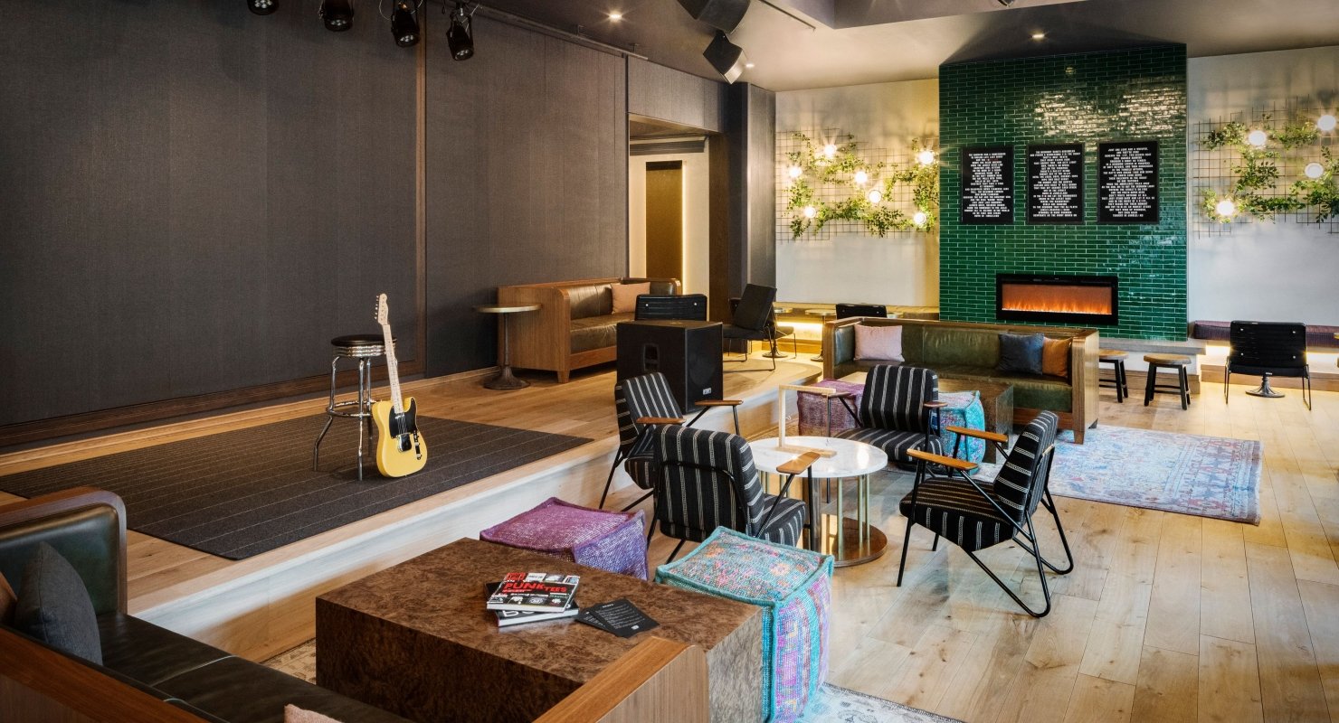 A guitar leaned up against a stool at the stage area of Magic Rat