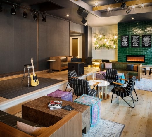 A guitar leaned up against a stool at the stage area of Magic Rat