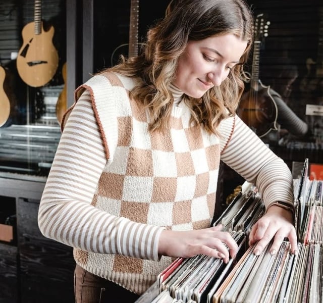 A woman looks through a crate of vinyl records at the Elizabeth Hotel