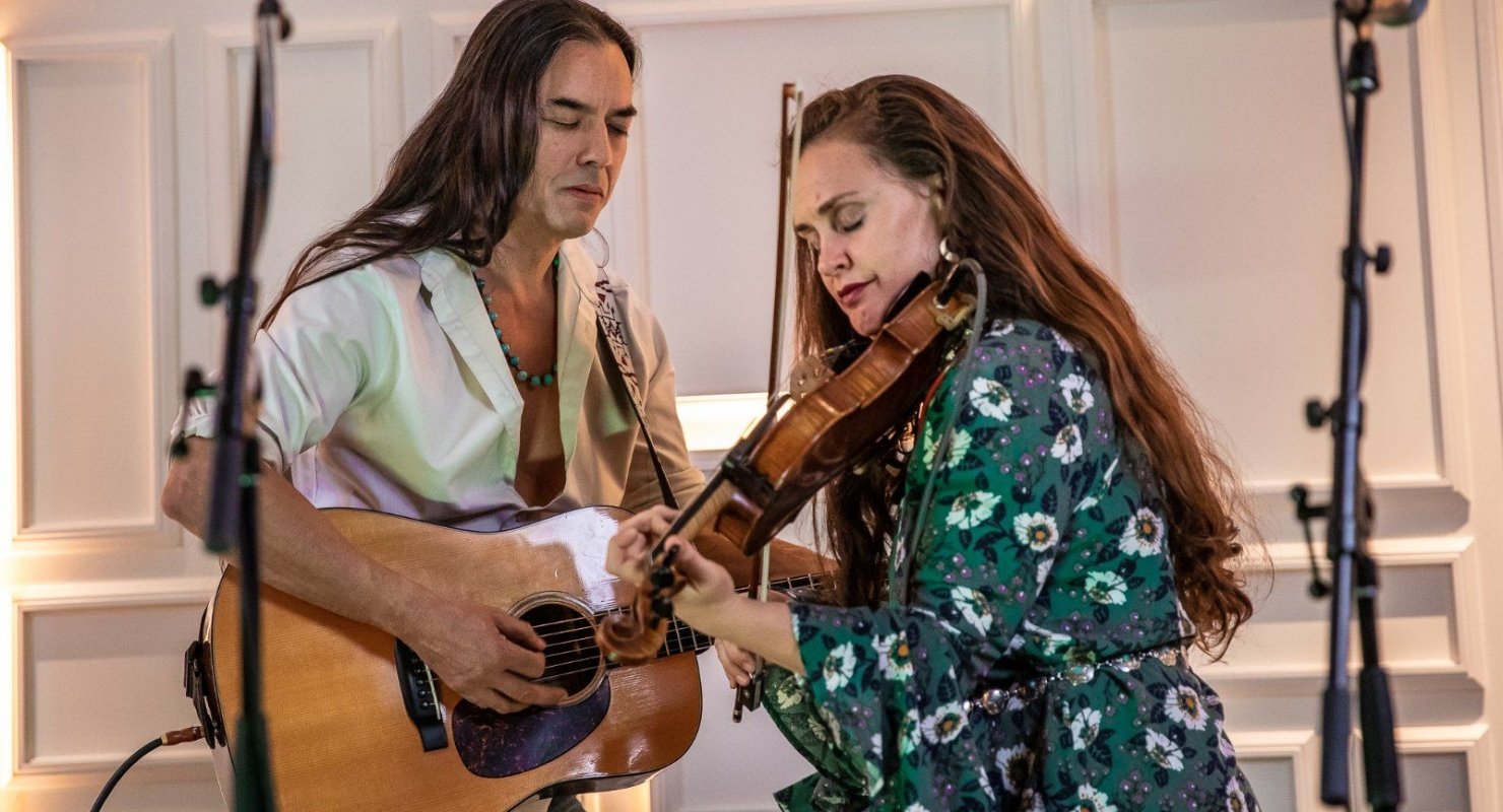 A guitar and fiddle duo play at the Sunset Lounge