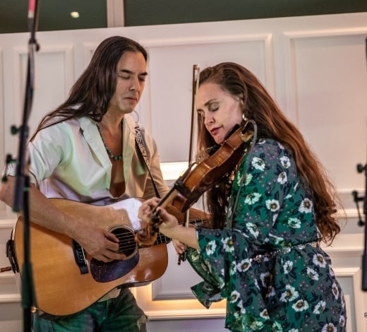 A guitar and fiddle duo play at the Sunset Lounge