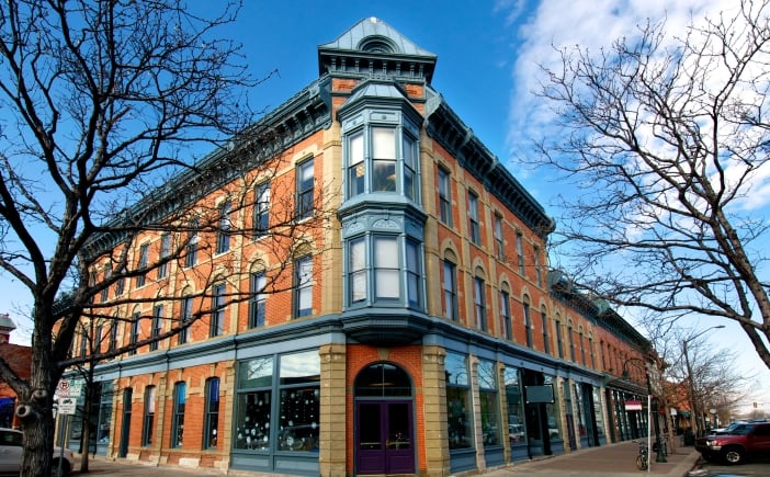An early-20th century style brick market hall building on a tree-lined corner