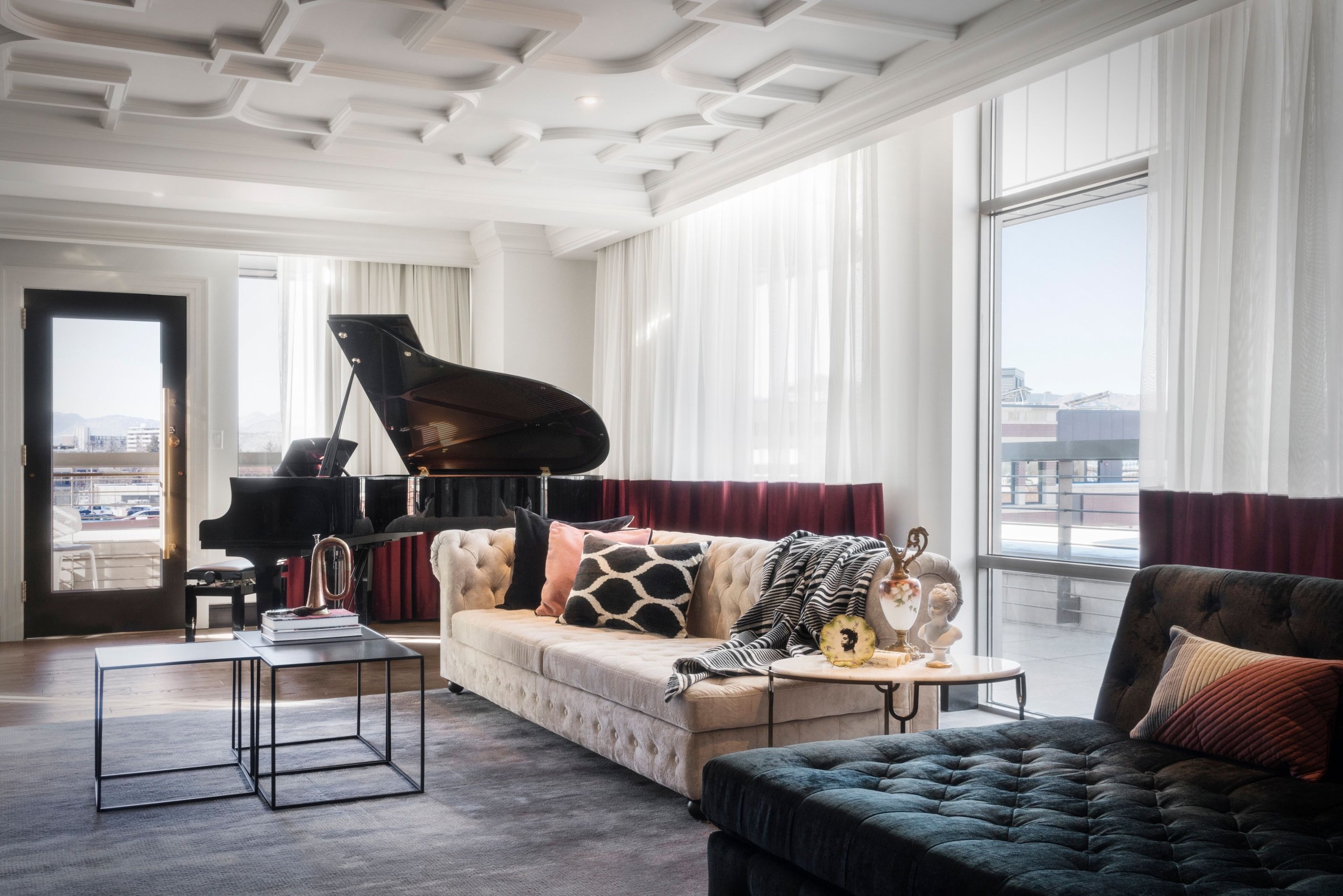 An Elizabeth Hotel suite, with a high ornate white ceiling, large couch and a grand piano