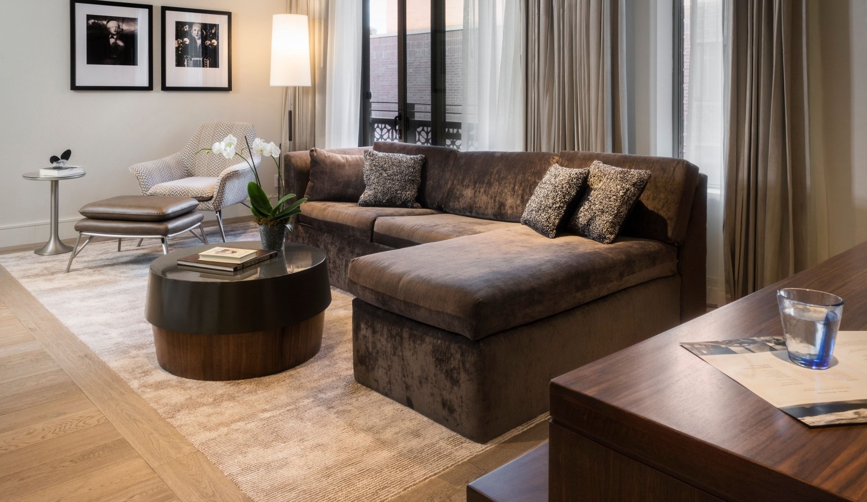 An Elizabeth Hotel suite living room with a large sectional couch, coffee table and workspace