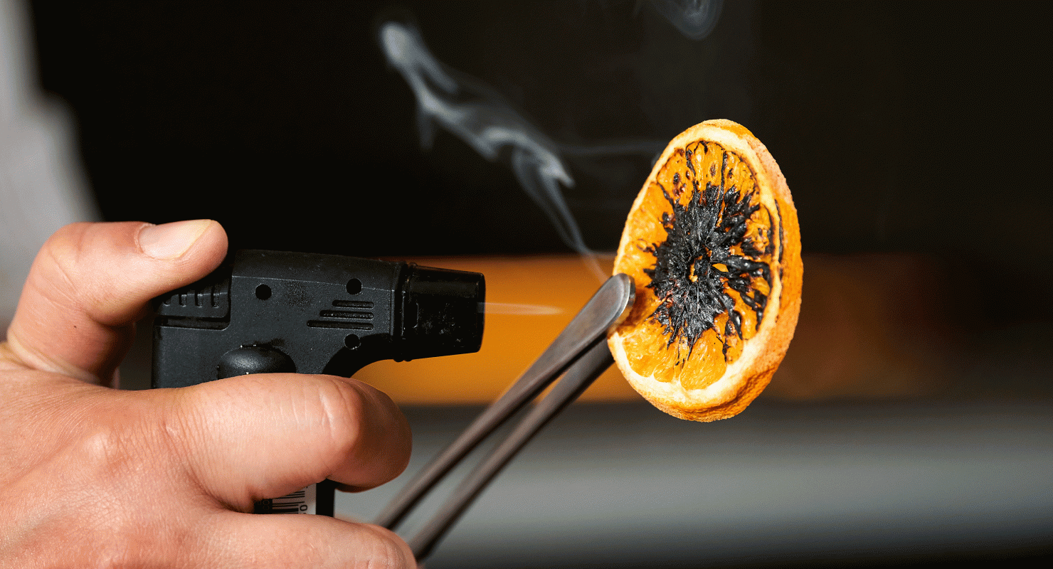 bartender preparing a drink with an orange slice