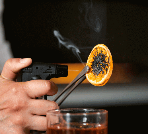 bartender preparing a drink with an orange slice