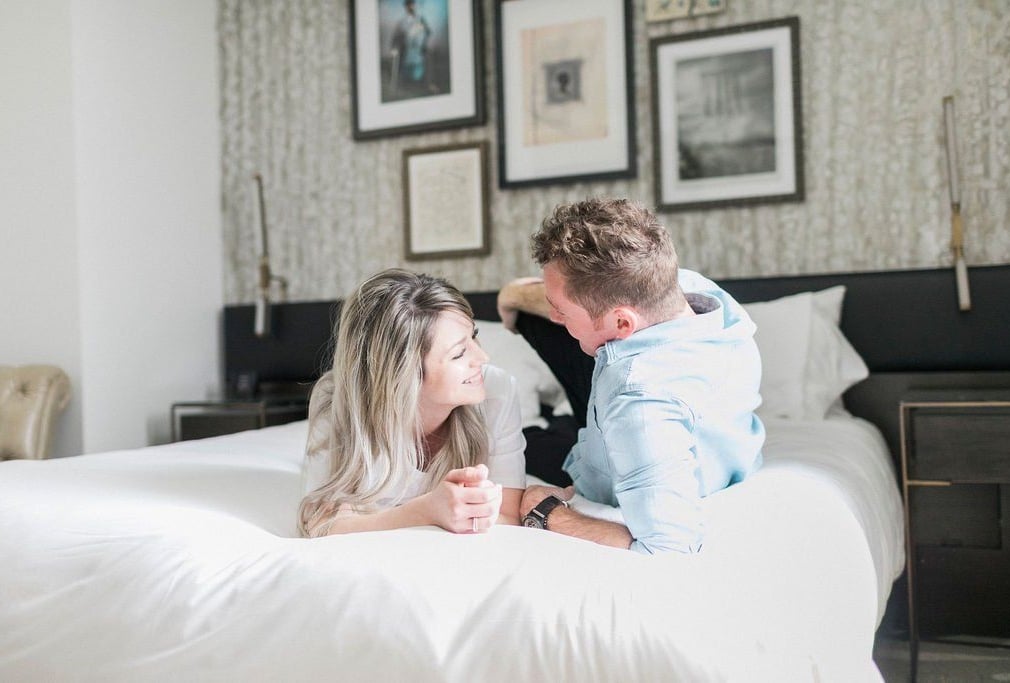 A couple relaxing on an Elizabeth Hotel bed