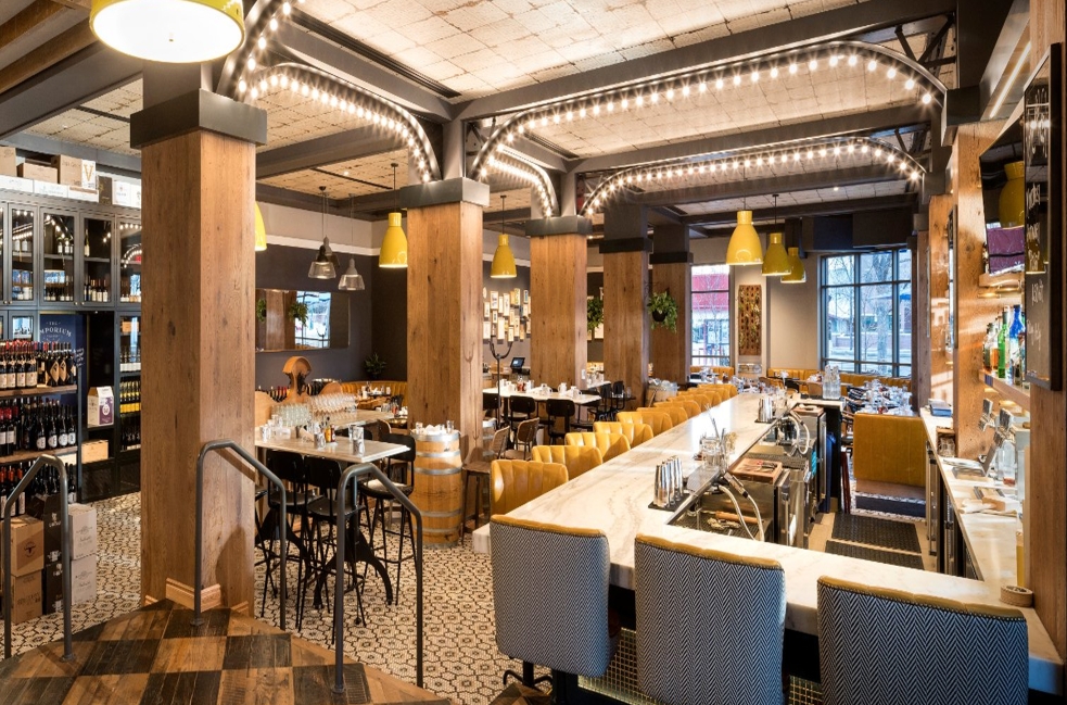 The bar and dining tables at the Emporium, a brasserie with checkerboard floors and string ceiling lights decorated in a mid-century style