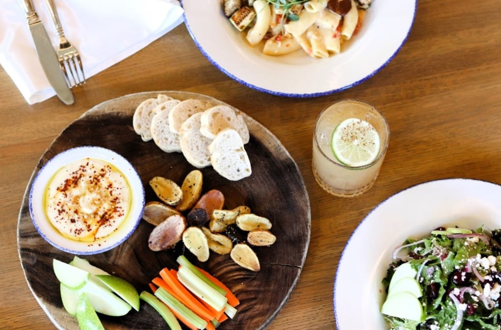 A table at the Emporium with dips, crudites, and pasta dishes
