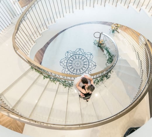 A couple hugging on the grand staircase of the Elizabeth Hotel