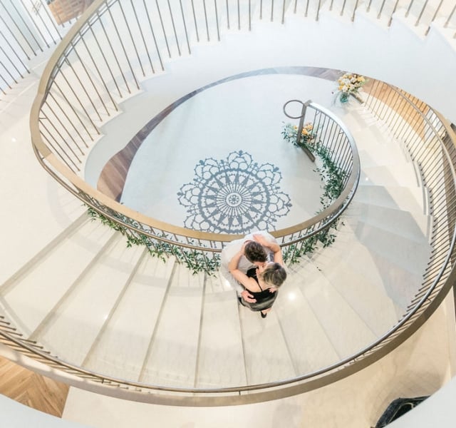 A couple hugging on the grand staircase of the Elizabeth Hotel
