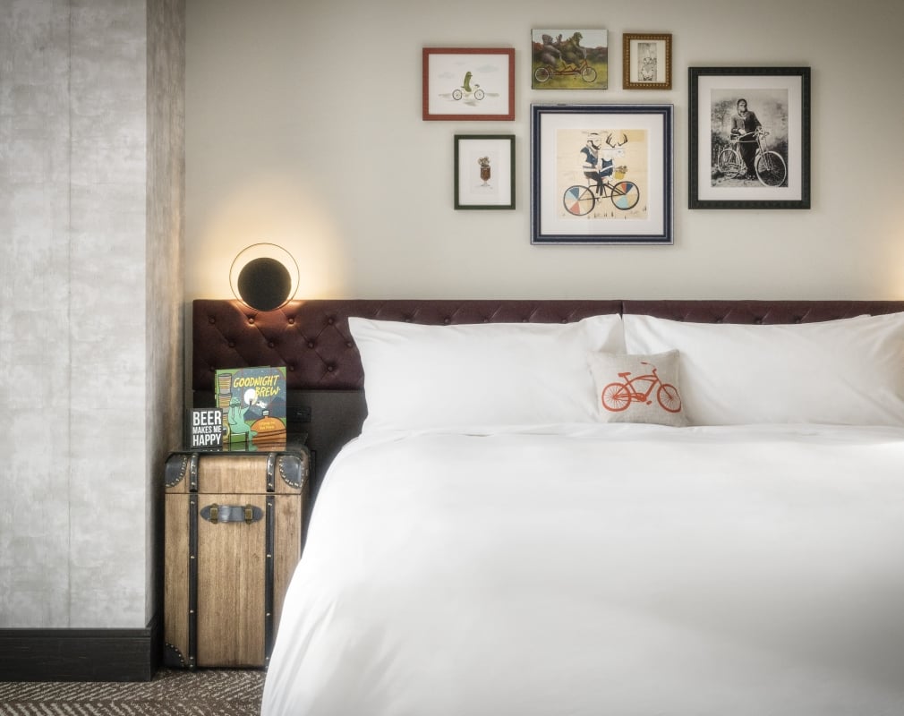 The Music Suite at the Elizabeth hotel, with a large King Bed adorned with a bicycle pillow