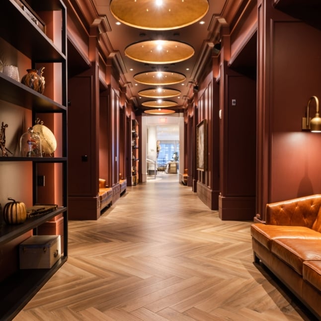 A long hallway red walls and parquet flooring in the lobby of The Elizabeth Hotel