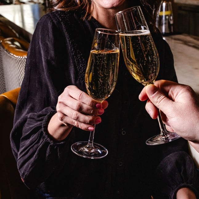 Two people clinking glasses of bubbly