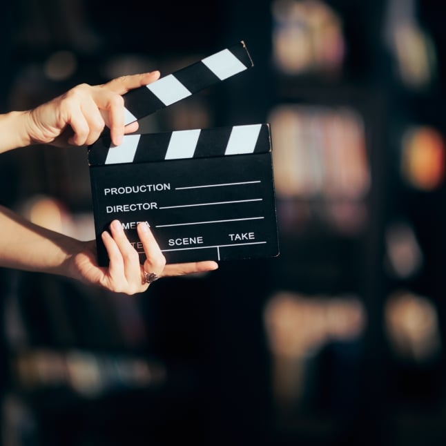 Hands Holding a Film Slate Directing a Movie Scene